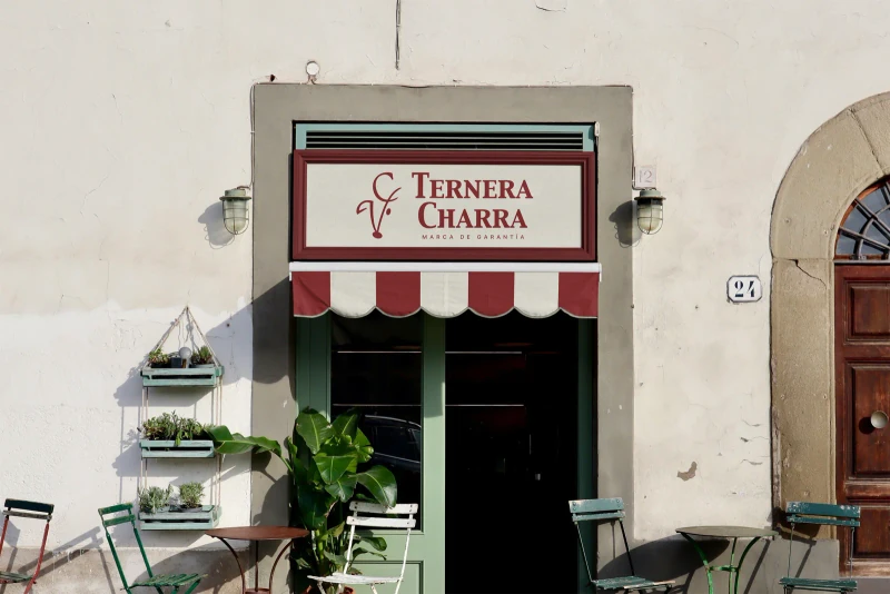 Fachada de la tienda Ternera Charra con su rótulo y toldo granate.